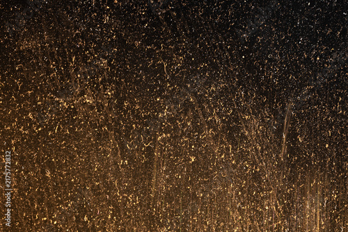 Warm brown scratched and dusty surface with vertical distressed marks and golden glow for vintage grunge texture background