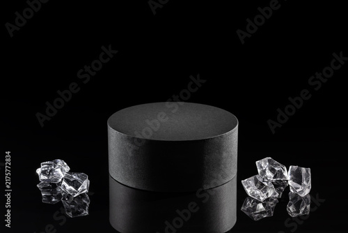 Black round podium with transparent ice crystals on glossy black background for luxury cosmetic product mockup or advertising