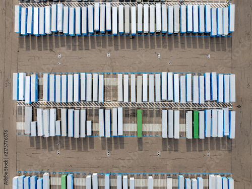 Top-down perspective of organized storage containers in an open, arid area