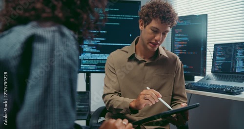 Diverse team developer uses tablet discuss AI coding and project strategy at office. Artificial intelligence software debugging, Cybersecurity database server, Machine learning app meeting concept.