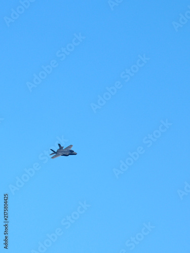 Фотография Modern Military Stealth Fighter Jet Flying in Clear Blue Sky