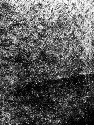 High contrast monochrome paper texture with dense grain, dark distressed areas and irregular marks, creating a dramatic rugged abstract surface