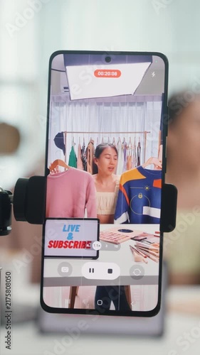 Vertical Screen : Close-up phone screen record Asia lady vlogger look phone camera review sweater new collection live selling online in story work at home studio. Business online media concept.
