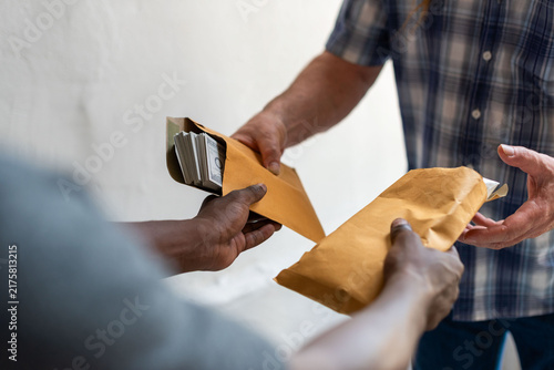Obraz na płótnie Men exchanging sealed envelopes in a discreet handoff