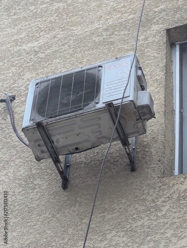 Фотография Vintage AC unit fixed to the facade of a building, right next to a window