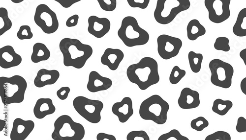 Bold animal print seamless pattern featuring irregular black spots on a clean white background, ideal for fashion.