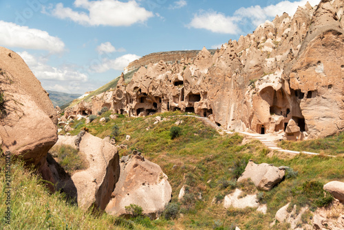Foto Ancient cave dwellings carved into volcanic rock formations in C