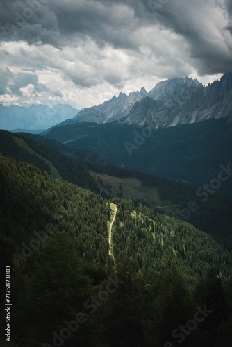 Dark Forested Mountain Slope with Moody Clouds