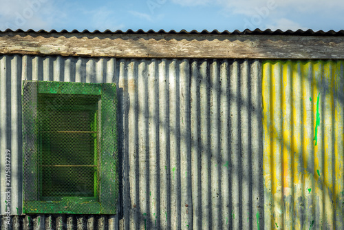 Canvastavla Colourful corrugated iron wall, barn window and blue sky
