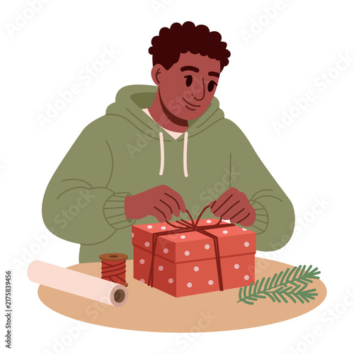 Young black man decorating a wrapped Christmas present with a red ribbon. Flat vector illustration.