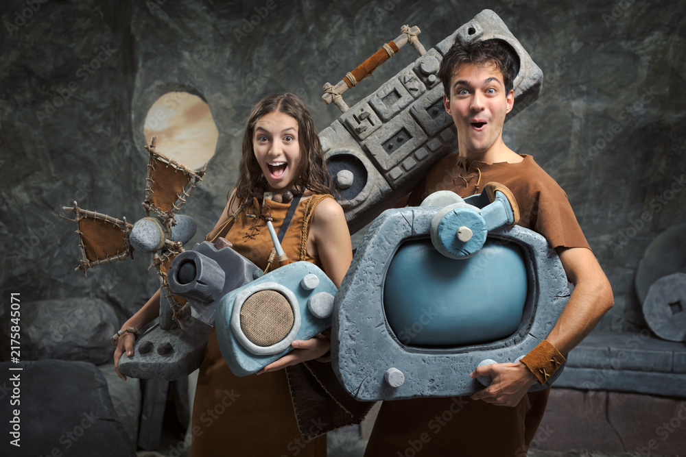 Fototapeta premium Prehistoric Couple Carrying Stone Electronics