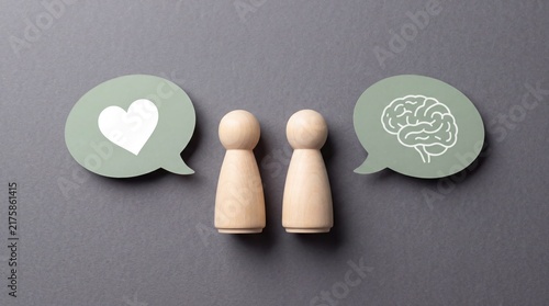 Two wooden figurines with speech bubbles representing communication and connection