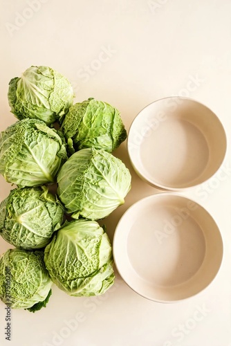 Whole Cabbages Stacked Beside Large Basins Ahead Of Winter Kimchi Making Gathering On Clean Pastel