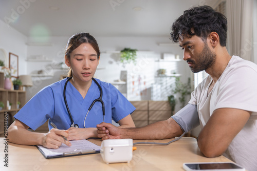 Cuadro en lienzo Healthcare professional measuring male patient blood pressure during medical checkup, monitoring vital signs while recording results for preventive care, health assessment, patient wellness