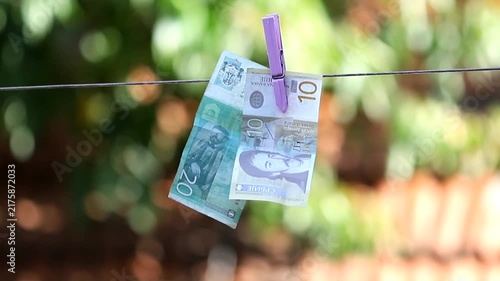 A Serbian dinar bill hanging from a clothespin