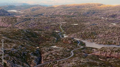 the sprawling mountain plateau and twisting asphalt of Lysevegen road heading towards Lysebotn, Rogaland, Norway
