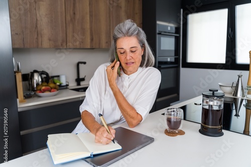 Mature white woman writing in notebook