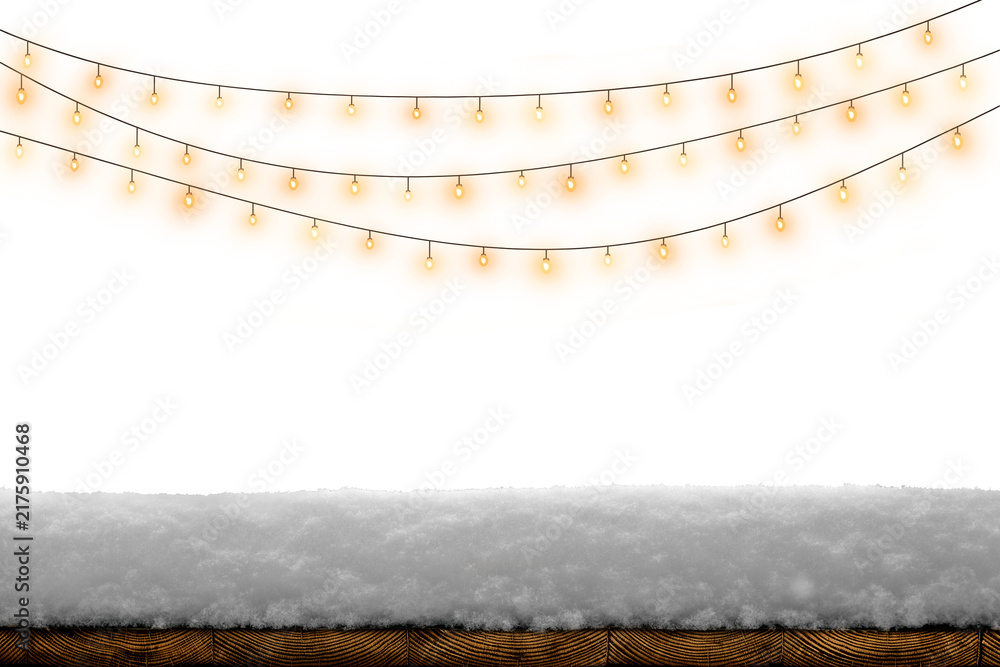 Obraz premium Warm glowing string lights above snow on a rustic wooden board, creating a cozy winter holiday background.