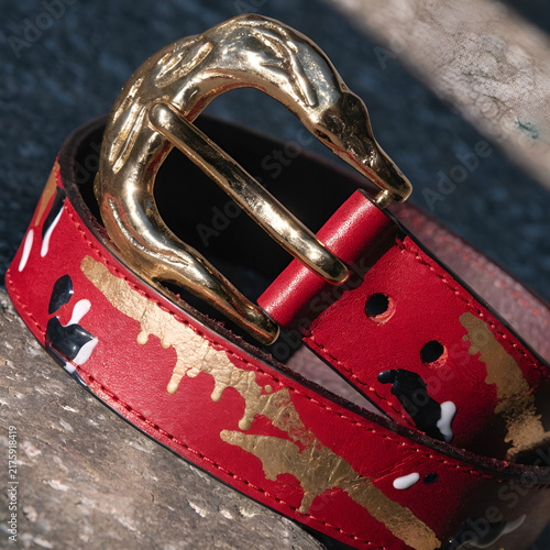 gold and red leather belt with splashes of paint