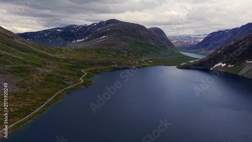 Aerial drone overview showing the dramatic topography of the alpine valley and the long road along Djupvatnet, Norway