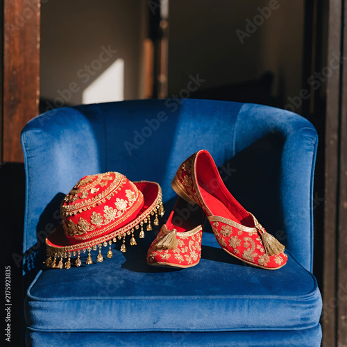 red Indian groom shoes and hat lie on the blue