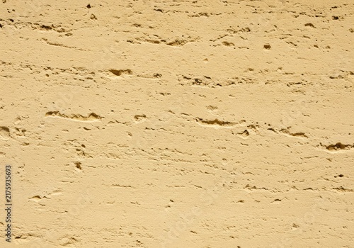 Detailed close-up of pale yellow oolitic limestone facade showing fine grain texture and weathered surface patterns used in historic construction ,close up ,cut stone ,block