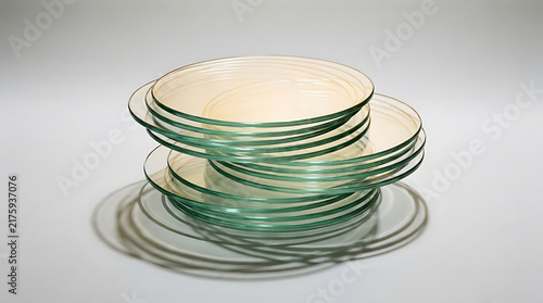 Stack of Petri Dishes: A close-up shot of a stack of clear glass petri dishes, commonly used in laboratories for culturing microorganisms.