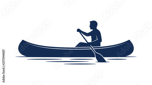 Silhouette of a man paddling a canoe on calm water