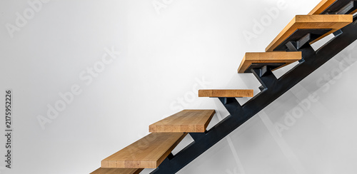 Wood and black metal staircase detail. Modern interior architecture with open steps.