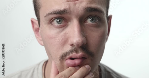 Extreme Close-up of Pensive Young Man Touching Chin and Thinking on White Background
