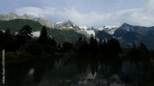 Obraz na plátně majestic snow-capped mountain reflected in a serene lake with pine forest, Chamo