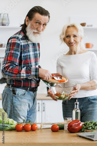 Photography An elderly couple happily prepares a fresh salad together in a bright, modern ki