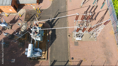 Aerial view of the Bourne West NGED 132kV Substation with electrical transformers, high-voltage equipment, and gravel grounds in Bourne, England, United Kingdom.