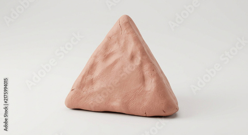 Hand-molded triangular clay sculpture with visible fingerprints on a clean neutral background