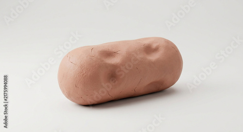 Pink molded clay cylinder with visible fingerprints and texture on a light studio background.