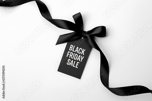 Black friday sale tag with a decorative black silk ribbon isolated on a white background