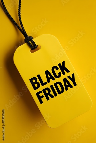 A yellow price tag with the text black friday hanging against a matching vibrant yellow background