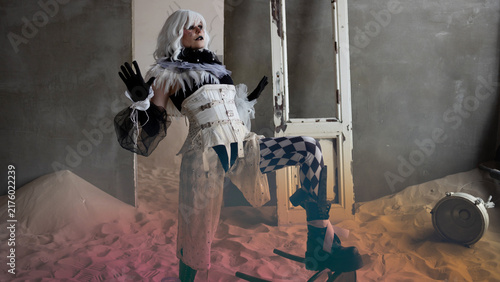 Canvastavla Theatrical circus performer in harlequin costume mid movement on post apocalypti