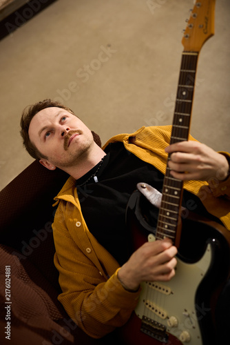 Принти на полотні Caucasian composer arranging guitar motifs in reflective pose