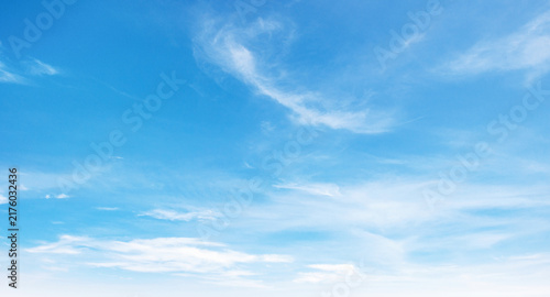 Clear blue sky with soft, wispy clouds