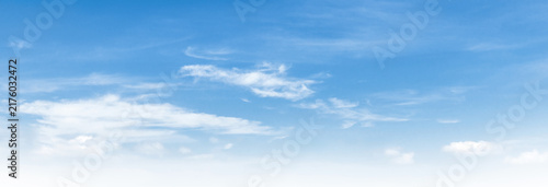 Clear blue sky with wispy clouds drifting above