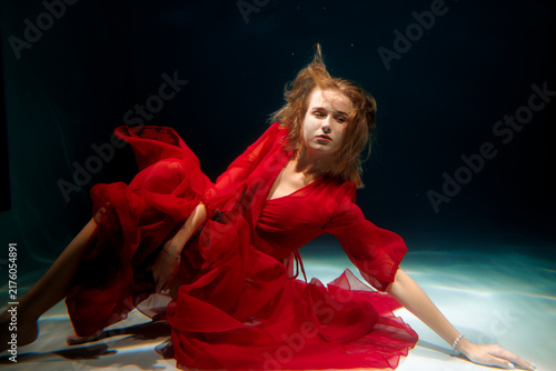 Fotografie Underwater confident stare caucasian woman in red dress glamour