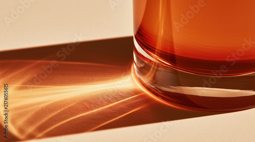 Amber glass vessel casting warm light and shadow