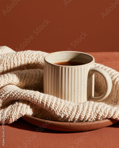 Warm coffee mug wrapped in cozy knitted blanket