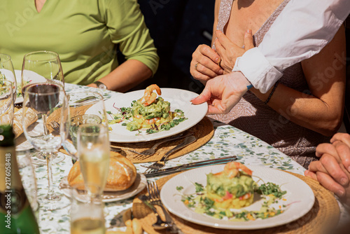 Waiter serving a fresh salad to a guest at a restaurant table