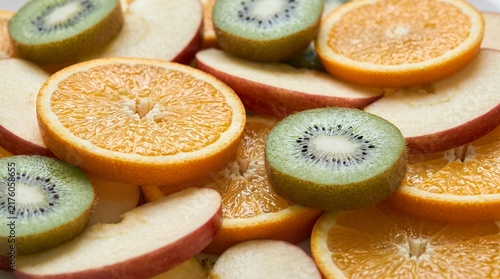 Fresh sliced fruits including orange, kiwi, and apple arranged together