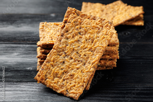 Bild auf Leinwand Wholegrain Cheese Crispbread with Mixed Seeds on Dark Background