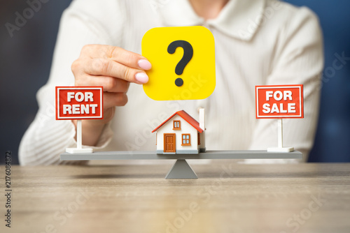Buy or rent a house. Sell the house or rent it out for regular income. Property decision concept shows investment strategy, housing market choice, and income planning. Female hand and question mark