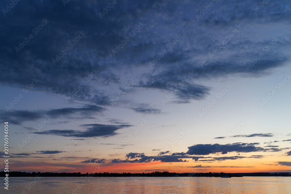 Obraz premium Dramatic twilight sky over river horizon