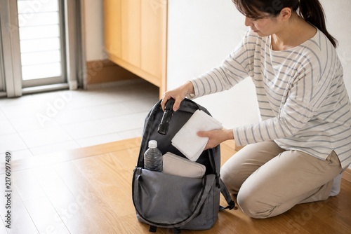 自宅で避難用バッグを準備する日本人女性